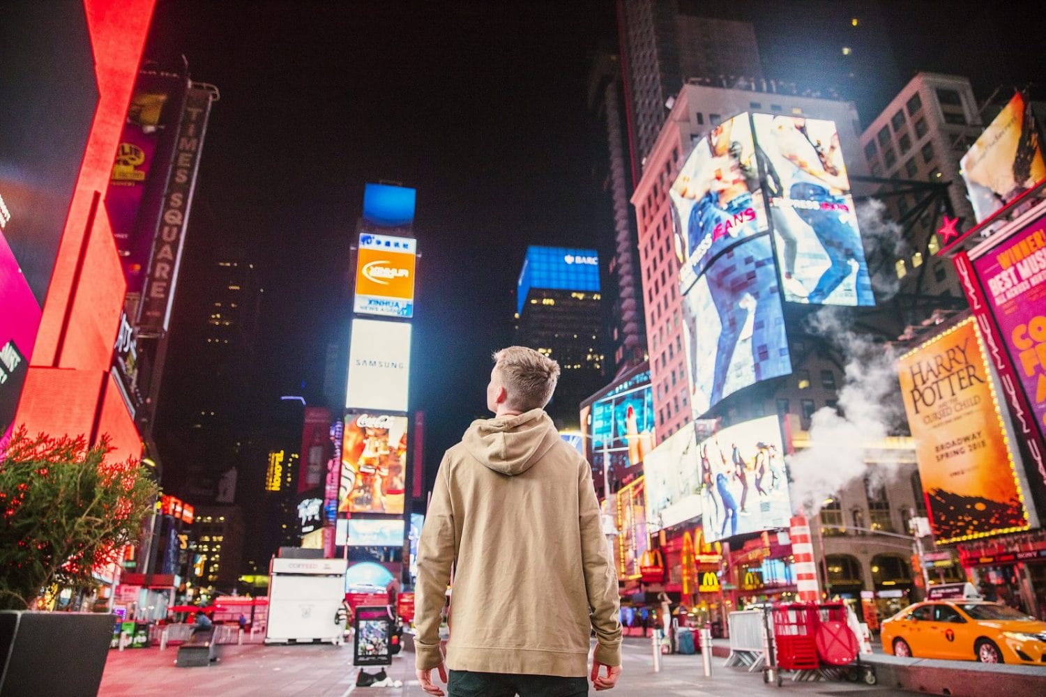 Una persona en Time Square contemplando una gran cantidad de anuncios